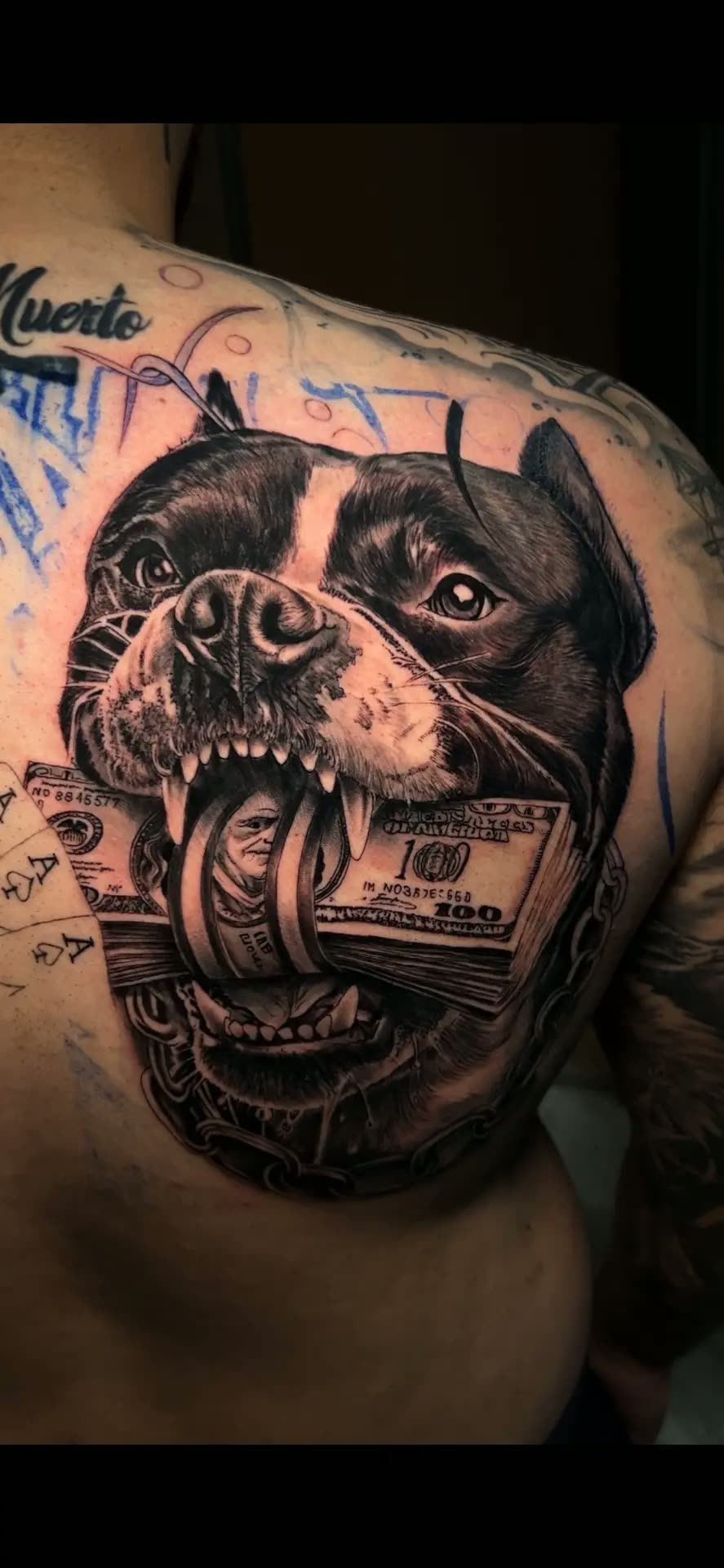 Tatuaje realista de perro con billetes en la espalda, black and grey